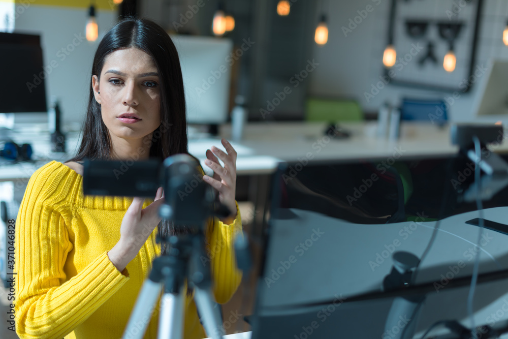 Attractive female blogger recording video for vlog. Gorgeous female coach and blogger giving antistress advice to her followers on video.
