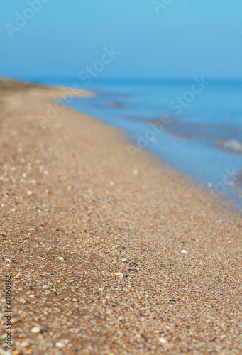 Surf on an empty shell beach  selective focus.