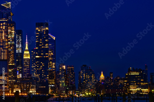 Manhattan skyline viewed from Weehawken New Jersey at dusk featuring illuminated buildings