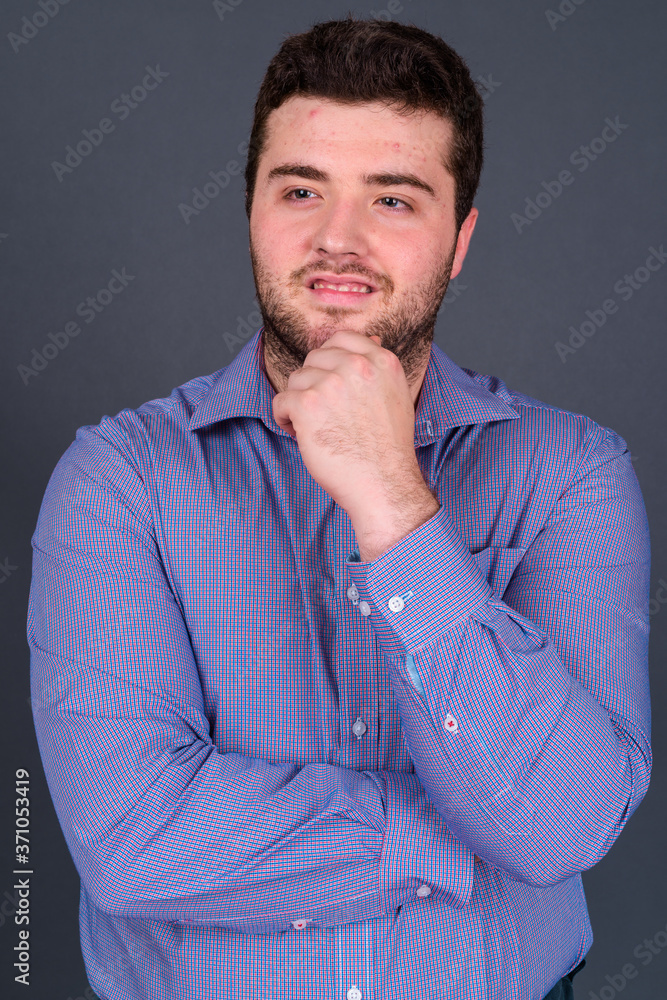 Portrait of happy young handsome overweight bearded businessman Portrait of happy young handsome overweight bearded businessman