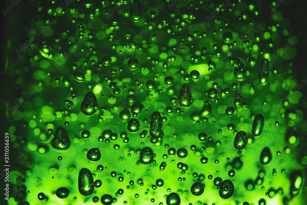 Bubbles of different shapes in green color, water droplets and abstract background. Bubbles pattern and illumination