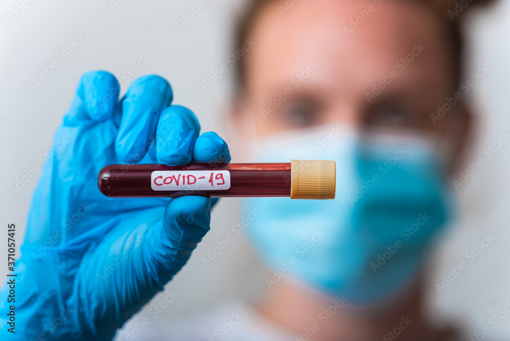 A bacteriologist is holding a blood sample to be tested for COVID-19 A bacteriologist is holding a blood sample to be tested for COVID-19