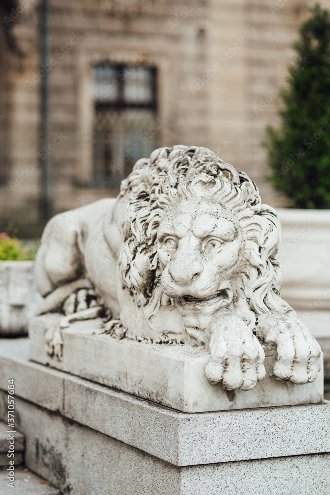 sculpture of a lion in a reclining position made of stone at the entrance to the castle