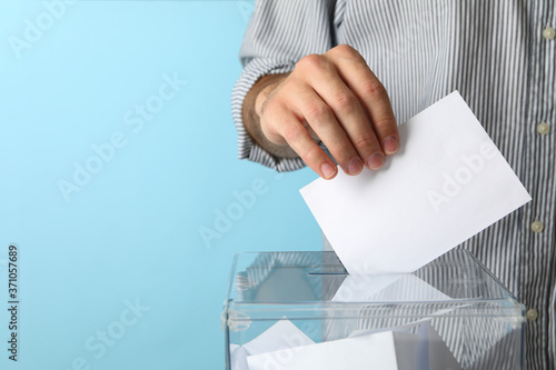 Billede på lærred Man putting ballot into voting box against blue background