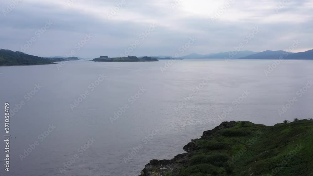 Aerial view of the sound of shuna and shuna island on the west coast of the argyll region of the highlands of Scotland during a summer storm showing a salmon fish farm
