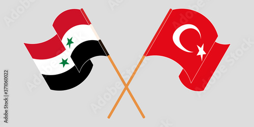 Crossed and waving flags of Syria and Turkey