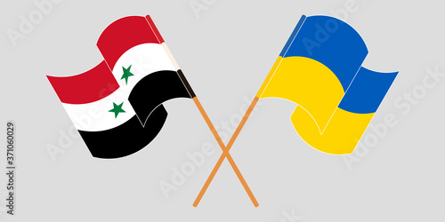 Crossed and waving flags of Syria and the Ukraine