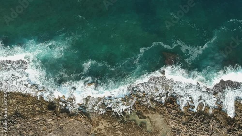 Aerial view glimpse of the coast south of Bari. The beach borders an agricultural land bordered by a dry-stone wall. Waves that have crashed on the coast