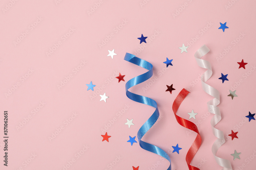 White, red and blue curly ribbons and stars on pink background