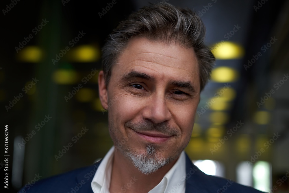 Portrait of happy mature man smiling and looking at camera. Confident businessman wearing suit, standing in office building hallway. Portrait of happy mature man smiling and looking at camera. Confident businessman wearing suit, standing in office building hallway.