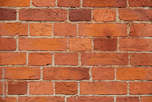 The wall of the building is made of old red brick. Background for text, posters. The brick is destroyed, the brick crumbles. Lots of bricks in the background. Background. Copy space.