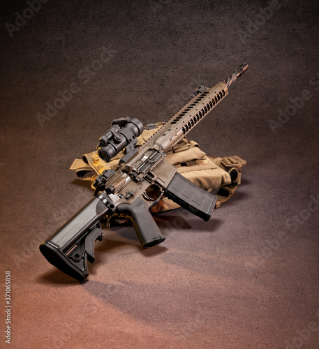 AR 15 style rifle displayed on top of gear, shot in studio. photo