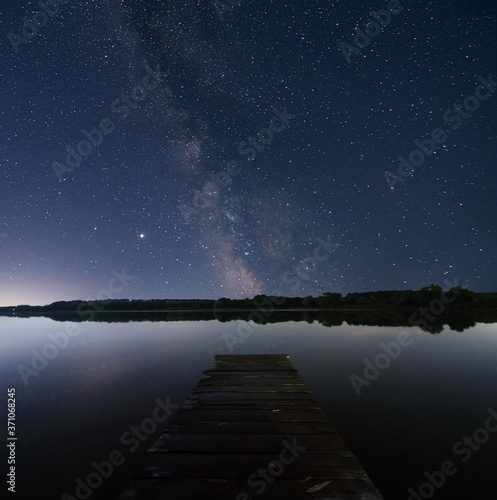 night sky over lake with litle pier photo