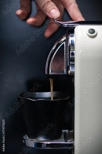 Coffee making using a coffee machine, hand pushing button