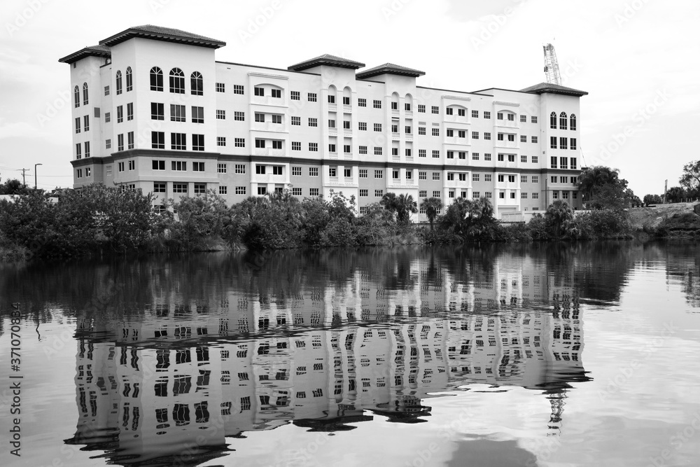 Black and white of a building being reflected in a waterway