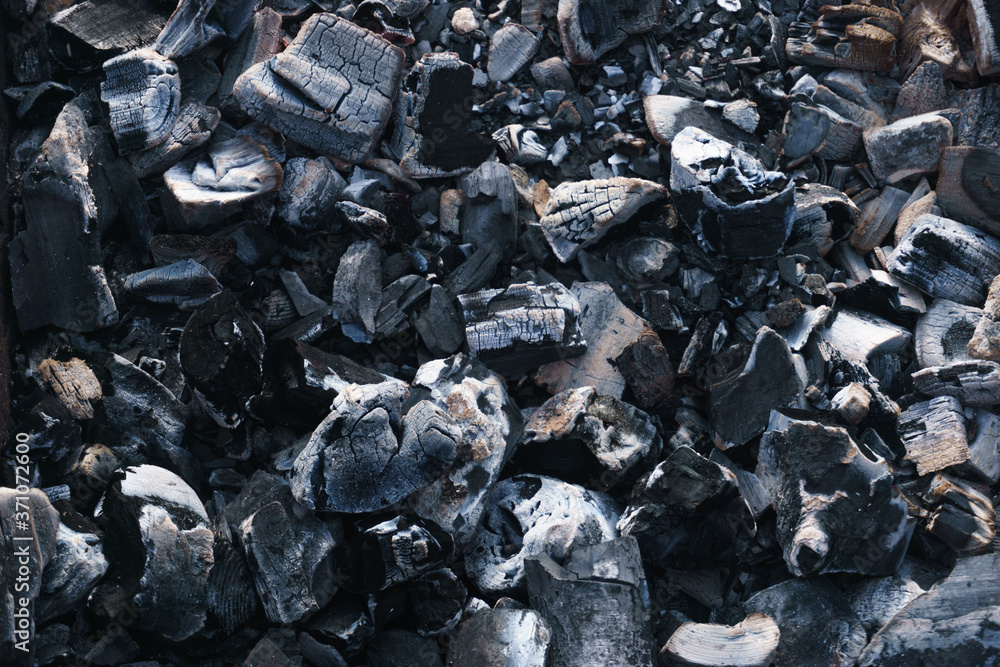 Hot coals and burning wood in the barbecue pit. Glowing and smoking charcoal, barbecue, red fire, and ash. Weekend. Hot coals and burning wood in the barbecue pit. Glowing and smoking charcoal, barbecue, red fire, and ash. Weekend.