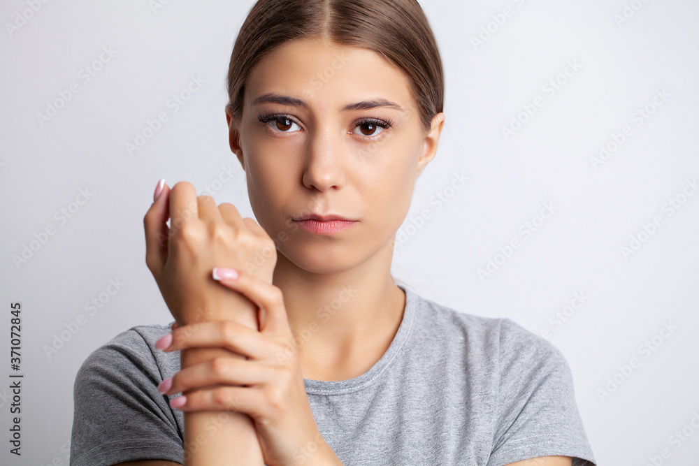 Young woman feels severe pain in her hand Young woman feels severe pain in her hand
