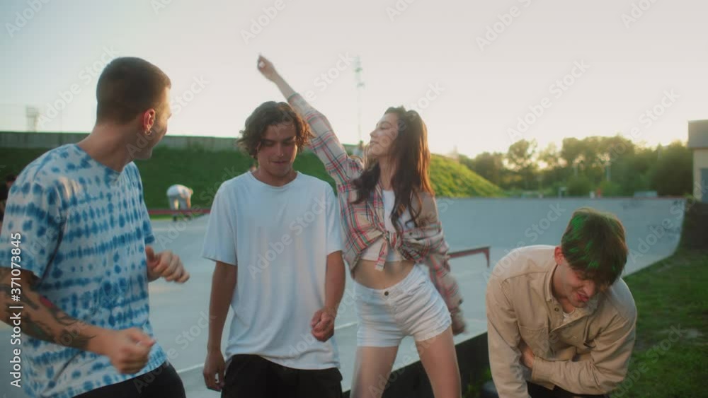 Friends hanging out and dancing at sunny skate park, summer generation z party, man and woman dance, millennials hip-hop subculture, european stylish young students, youngsters bloggers making video Friends hanging out and dancing at sunny skate park, summer generation z party, man and woman dance, millennials hip-hop subculture, european stylish young students, youngsters bloggers making video