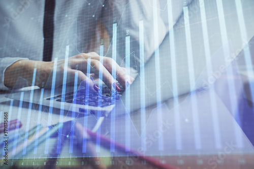 Double exposure of woman hands typing on computer and financial graph hologram drawing. Stock market analysis concept.