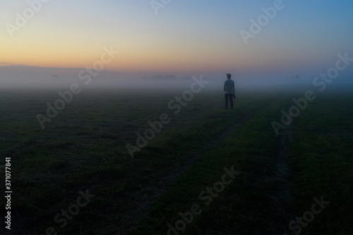 silhouette of a man walking in the fog