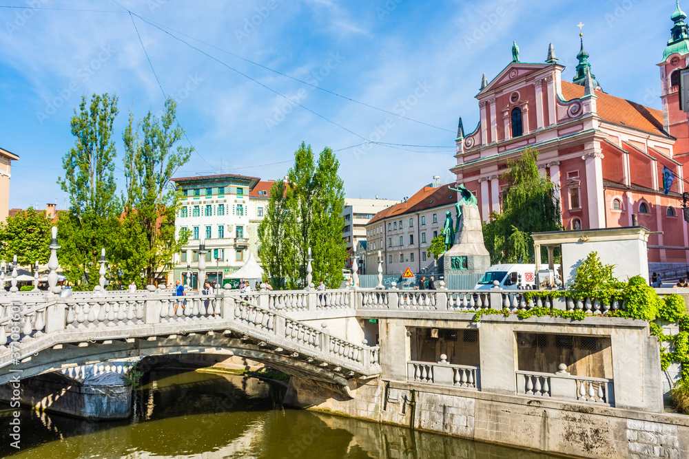 LJUBLJANA, SLOVENIA, 5th AUGUST 2019: Triple Bridge and Red church of historic center