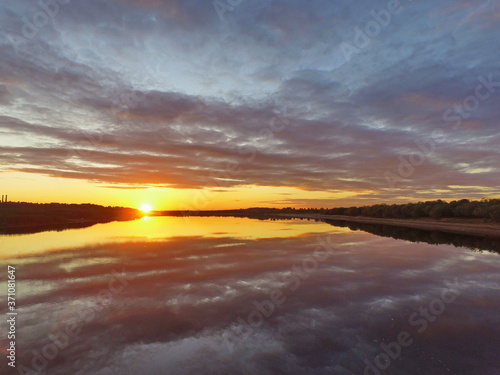 Reflection of a fiery sunset in the water. Vychegda River, Komi Republic, Russia.