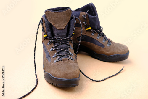 pair of men's trekking boots made of natural brown suede with modern technological materials, the concept of special shoes for various outdoor activities, sports