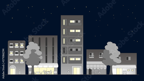 Cityscape at night. People come and go through the streets that are lined with apartments and cafes.