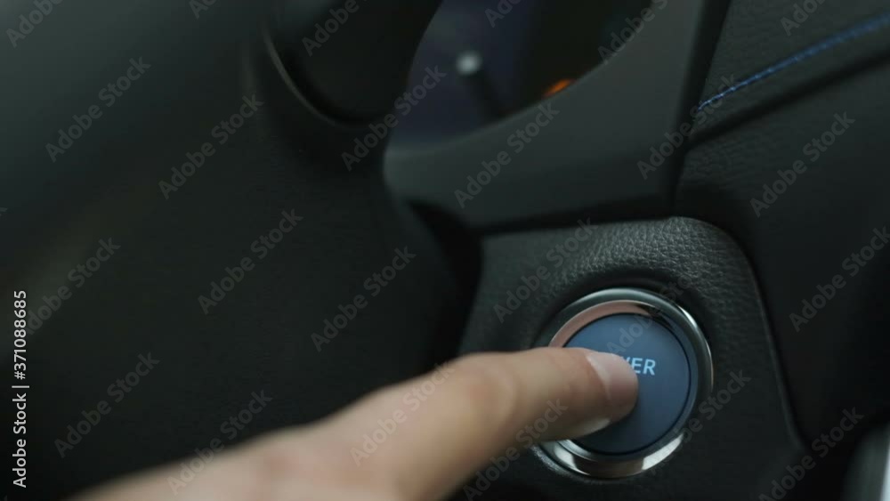 Finger Pushing blue button on hybrid car engine key less ignition power, to start drive Closeup slow Finger Pushing blue button on hybrid car engine key less ignition power, to start drive Closeup slow