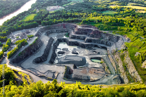 Aerial view of opencast mining quarry in the middle of the forest photo
