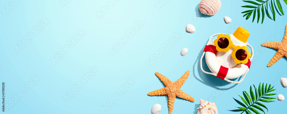 Fototapeta premium Sunblock bottle wearing sunglasses with starfish and seashells - flat lay