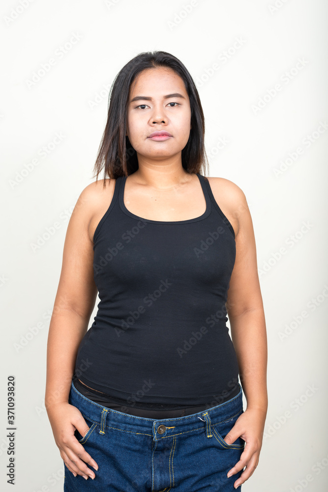 Portrait of young overweight Asian woman against white background Portrait of young overweight Asian woman against white background
