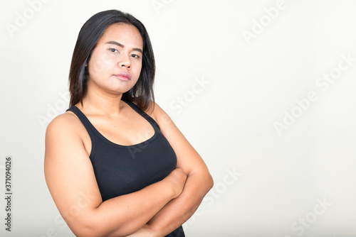 Portrait of young overweight Asian woman against white background © Ranta Images