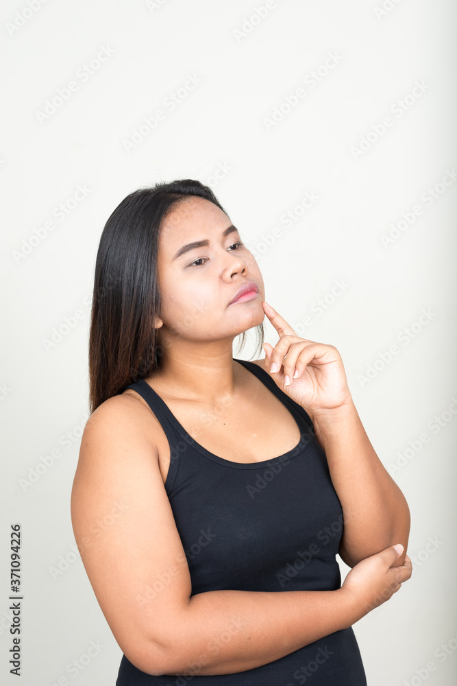 Portrait of young overweight Asian woman against white background Portrait of young overweight Asian woman against white background