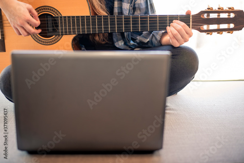 Woman learning online how to play guitar