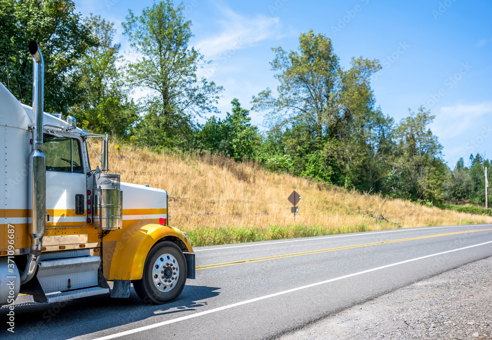 Big rig classic semi truck tractor with vertical chrome pipes running on the winding road in Columbia Gorge