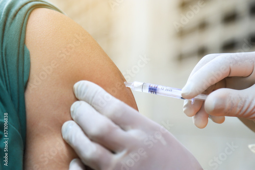 Wallpaper Mural doctor pressing needle syring injection vaccine to people at home for heaking ill Torontodigital.ca