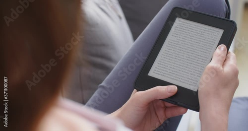 A woman reading an e-book at home.