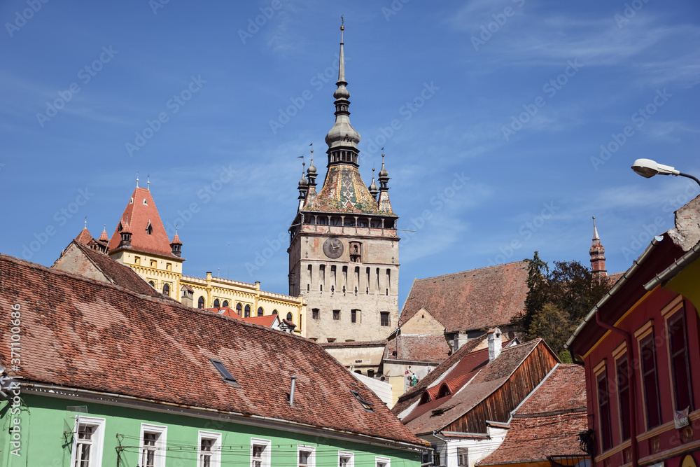 Sighisoara Clock Tower overhanging colored house in the historic town center
