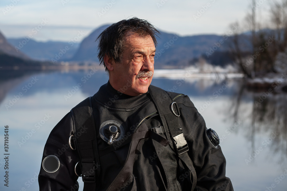 Mature Diver in a Drysuit After a Rescue Dive in a Freezing Cold Lake