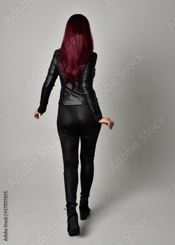 Samolepka Full length portrait of  girl with red hair wearing black leather jacket, pants and boots