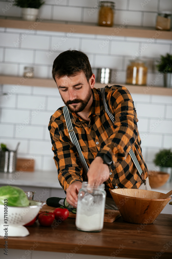 Portrait of handsome man in kitchen. Young man preparing delicious food. Portrait of handsome man in kitchen. Young man preparing delicious food.