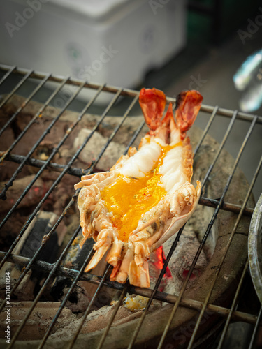 Roasted grilled fresh giant river prawn burn flaming on charcoal stove..
