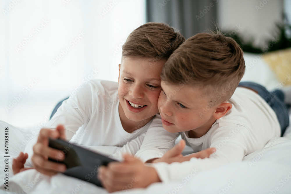 Two little brothers are playing games on the phone. Beautiful boys enjoying at home... Two little brothers are playing games on the phone. Beautiful boys enjoying at home...