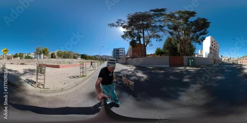Young Caucasian Man Wears a Beanie and is Skating with a Dog and a Young Girl and another Dog Run Behind him - Shot in 360