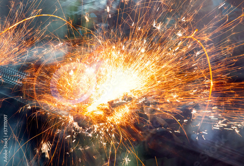 Hot sparks at grinding steel material - Sparks of welding.