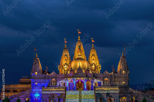 Lighted image of Shree Swaminarayan temple with monsoon clouds background, Ambe Gaon, Pune . photo