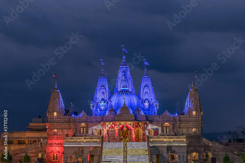 Lighted image of Shree Swaminarayan temple with monsoon clouds background, Ambe Gaon, Pune . photo