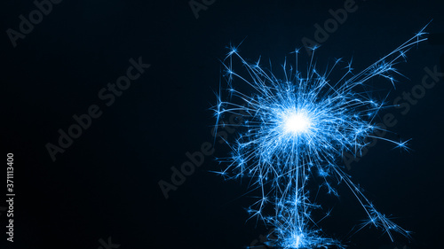 Burning colored sparkler  pyrotechnics on a black background. Merry christmas and happy new year  background  copy space