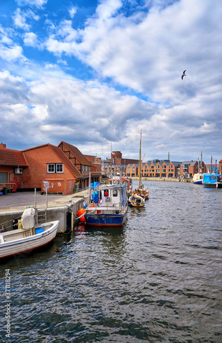 Fishing boats in the port of Wismar with a seagull in the sky.